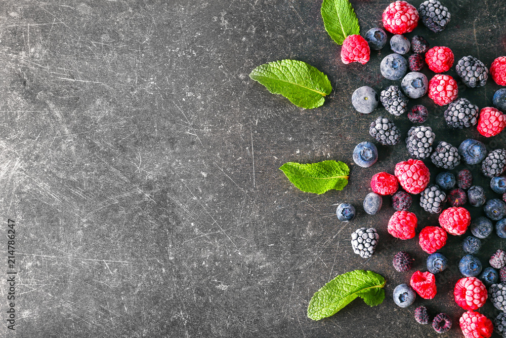 Delicious frozen berries on grey background