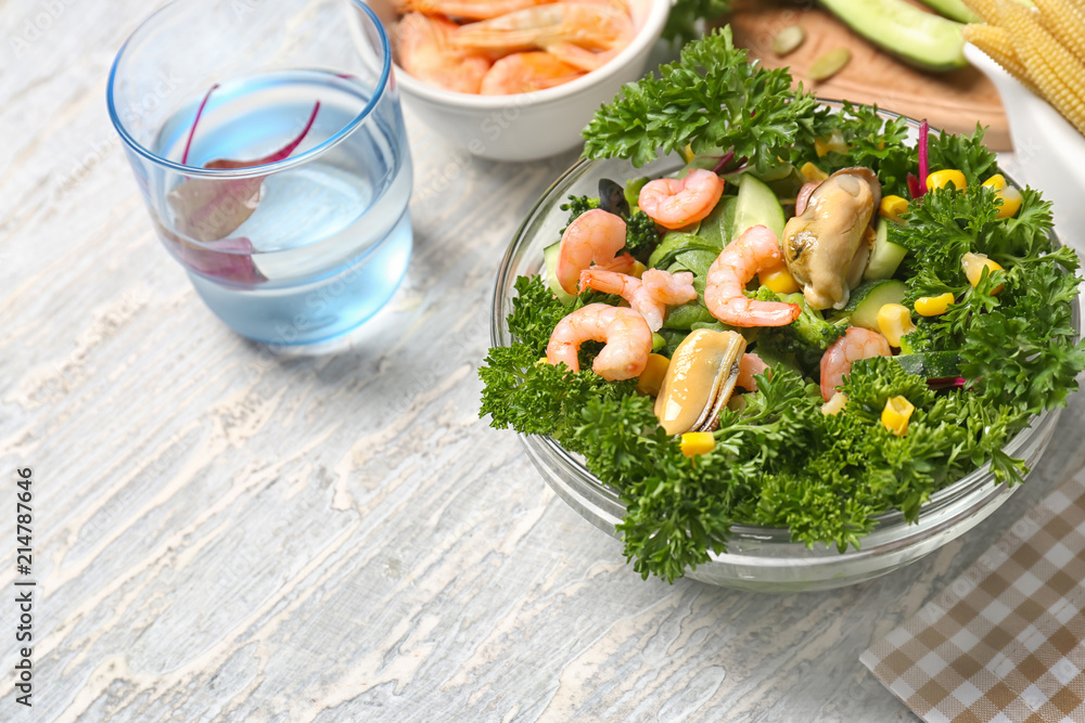 Bowl with tasty shrimp salad on table