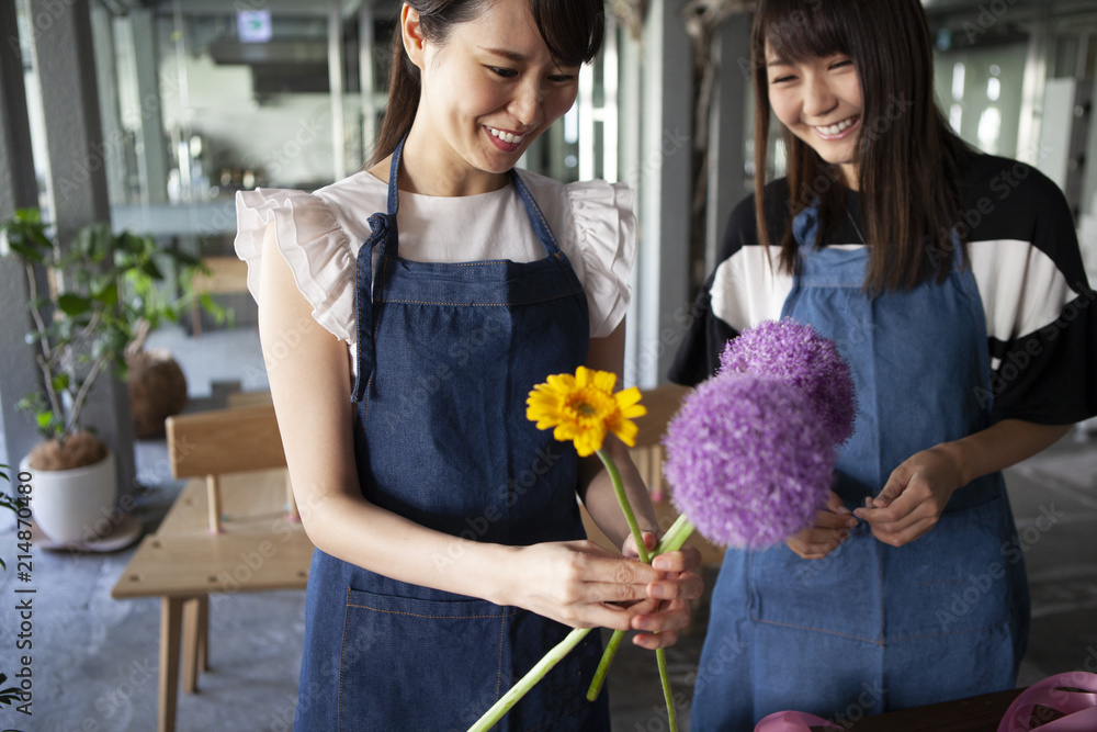 花を手に取り花束を作るには何が合うか考える花屋の店員