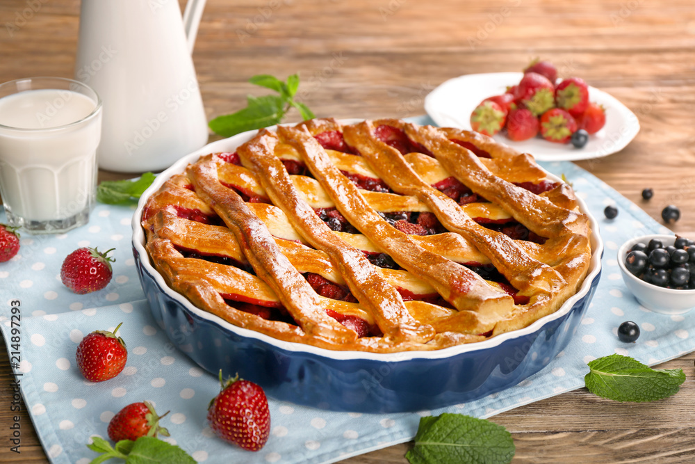 Tasty pie with berries on wooden table