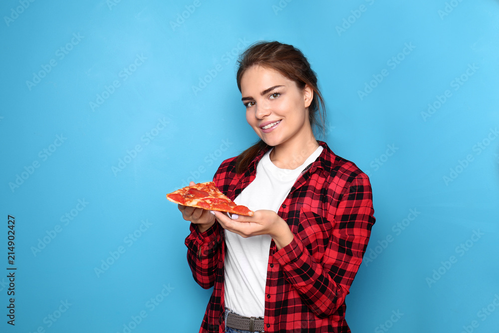 年轻女子在吃彩色背景的美味披萨