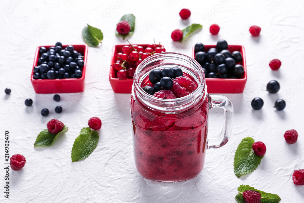 Mason jar with tasty berry smoothie on table