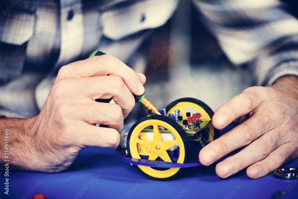 Closeup of hands working on robot wheels