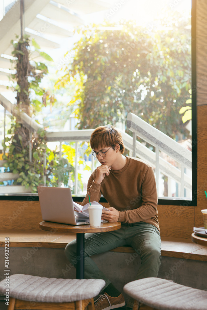 Cheerful male journalist in trendy glasses happy to finishing work on book review rereading written 