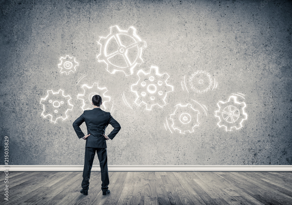 Cogwheel engine drawn on concrete wall as symbol for teamwork an