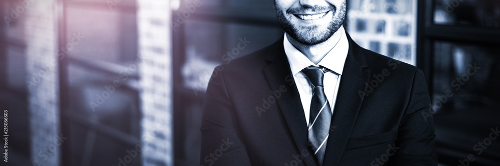 Handsome businessman with arms crossed standing in office