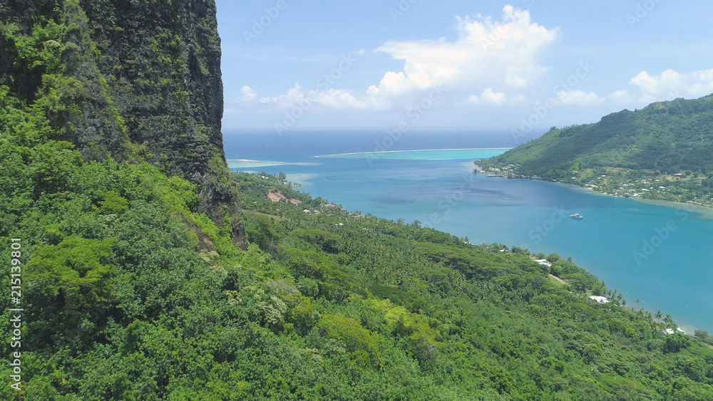 空中：靠近陡峭的山丘飞行，俯瞰阳光明媚的摩里亚平静的海湾。