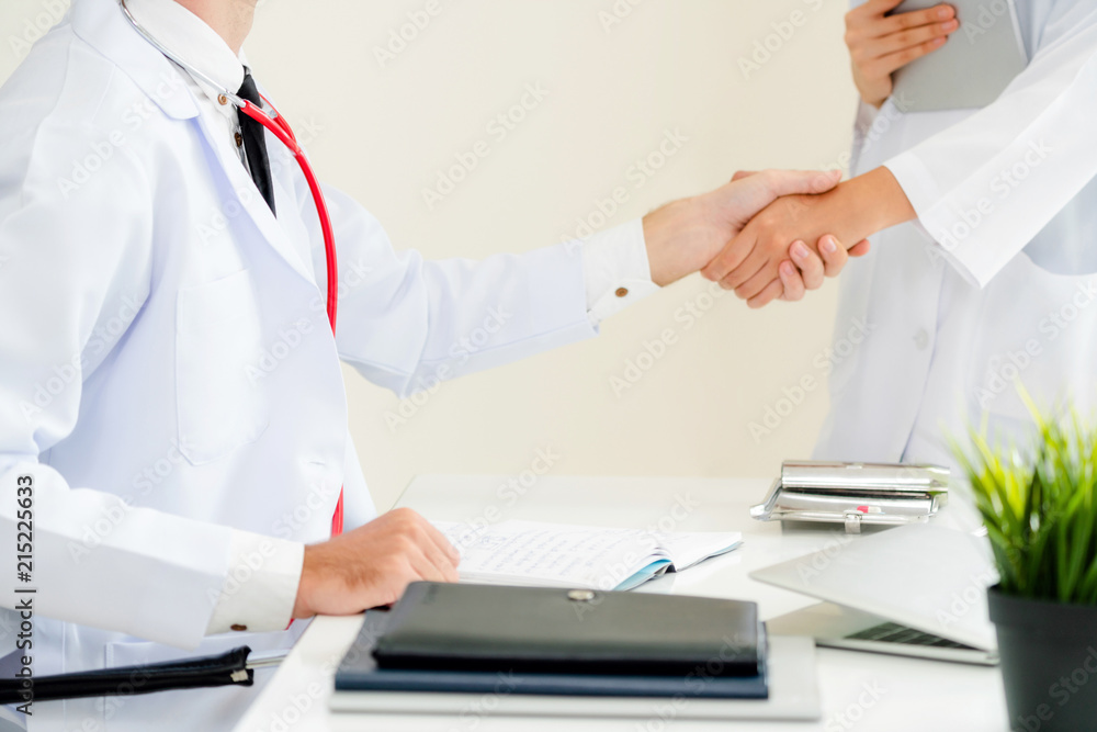 Doctor at hospital shakes hand with another doctor