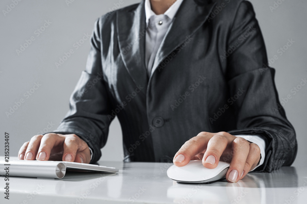 Closeup of businesswoman hand typing on keyboard with mouse on w