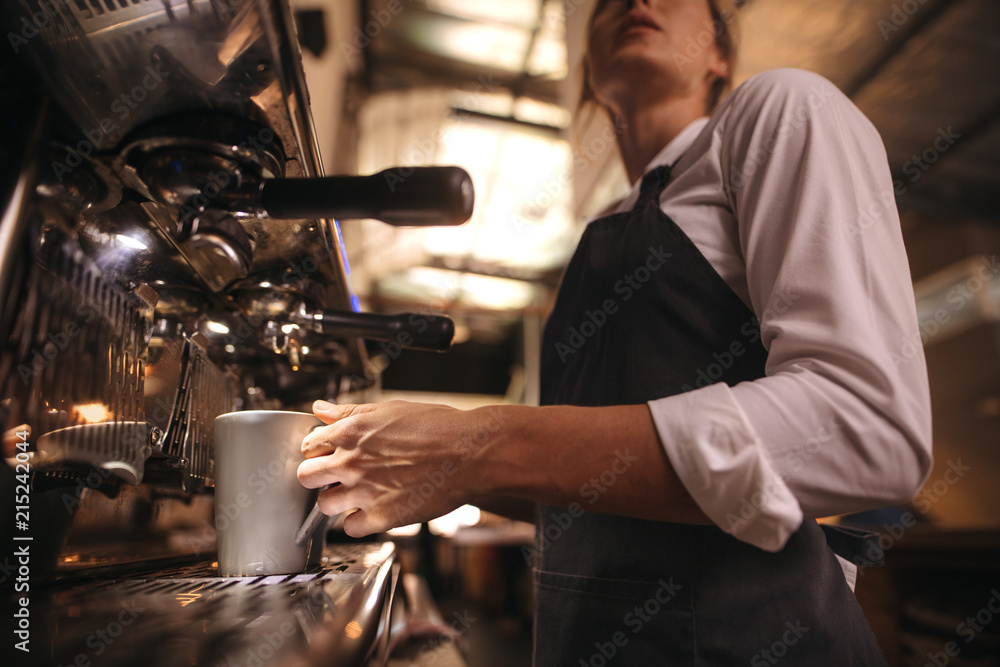 Barista making coffee on coffee maker machine