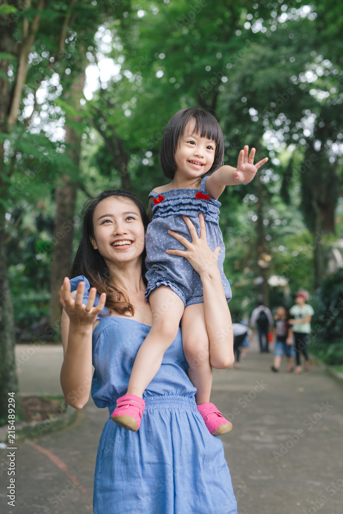 小女孩拥抱母亲的肖像，带着自然和阳光，家庭概念