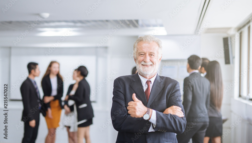 Happy businessman on the background of business team showing thumbs up