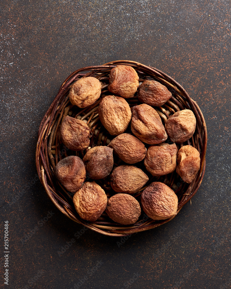 Sun dried apricots on brown background. Top view.