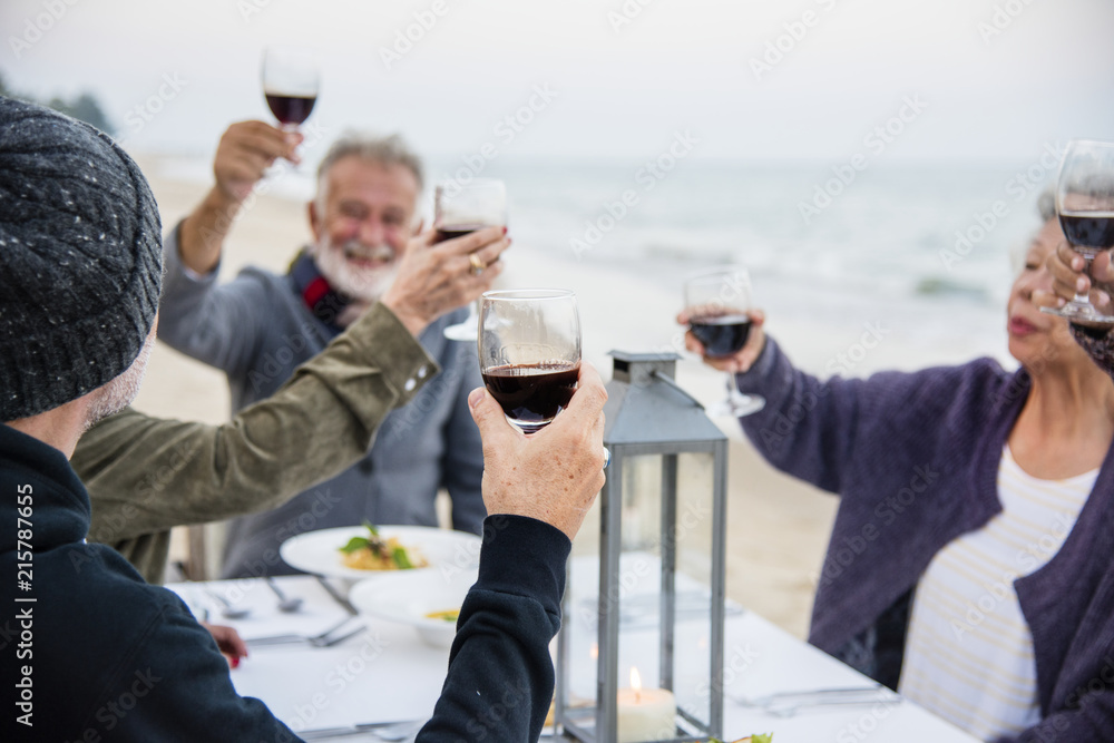 老年人在海滩上用红酒敬酒