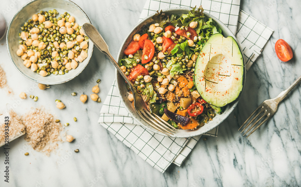 Vegan lunch bowl. Flat-lay of dinner with avocado, grains, beans, sprouts, greens and vegetables ove