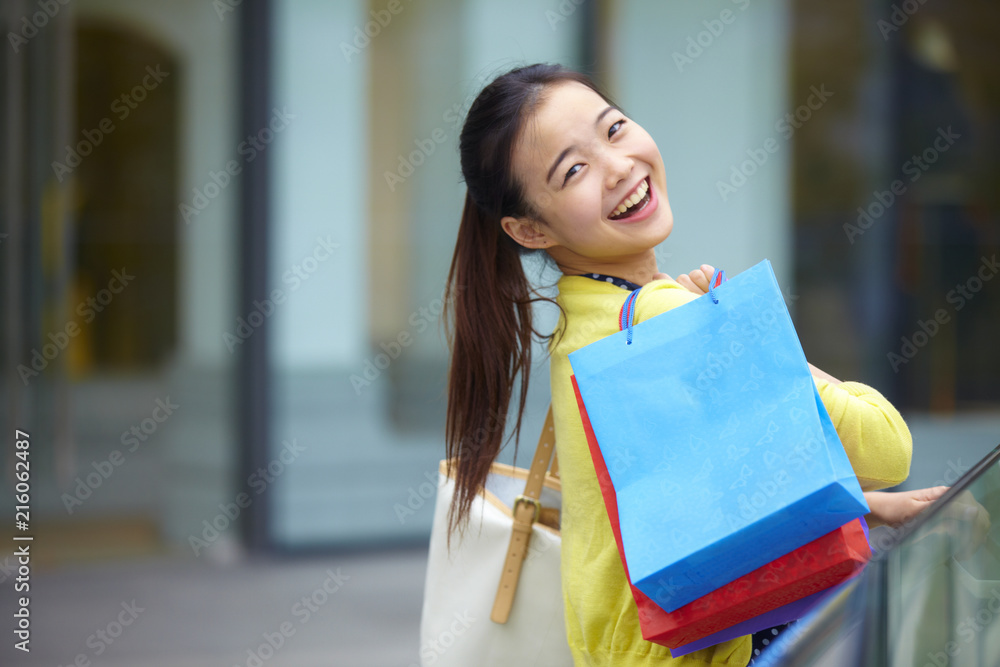 一个美丽的年轻女子在街上购物