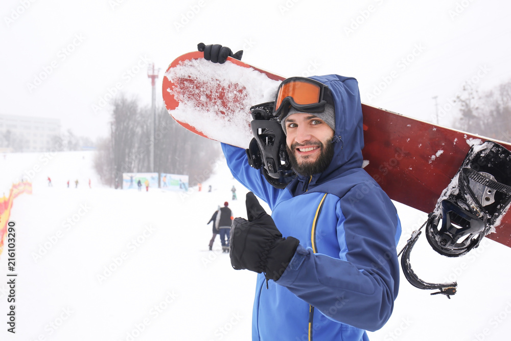 Male snowboarder on slope at winter resort