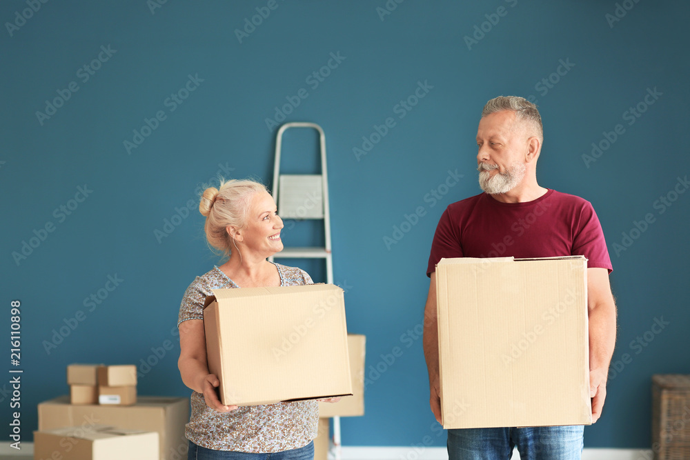 Mature couple with moving boxes at new home