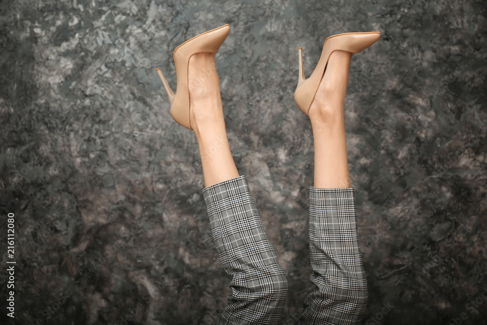 Legs of beautiful young woman on dark grey background