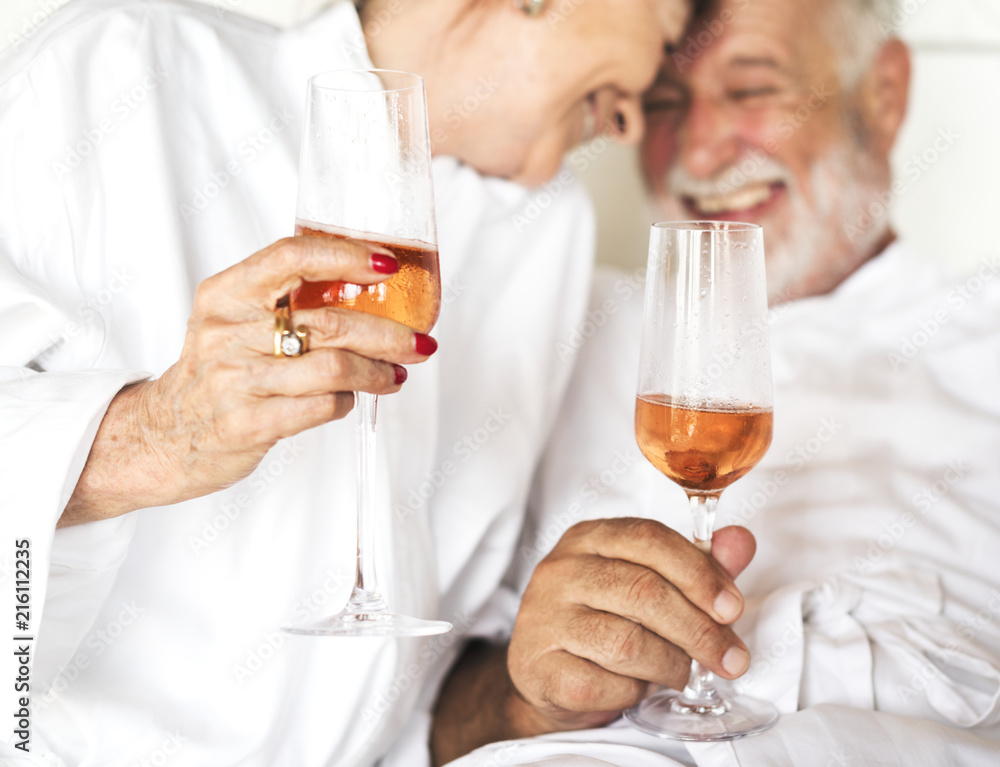 Couple having prosecco in bed