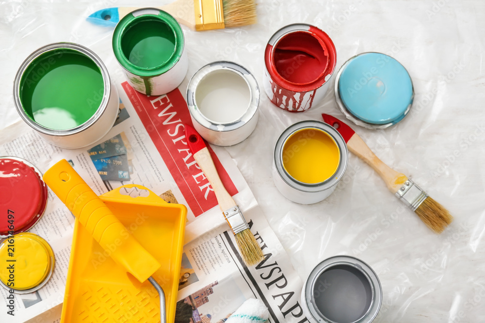 Paint cans with tools on table, top view