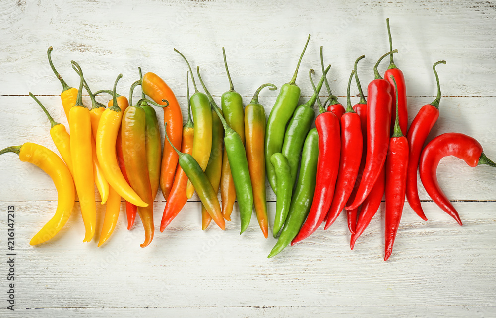 Chili peppers on white wooden background