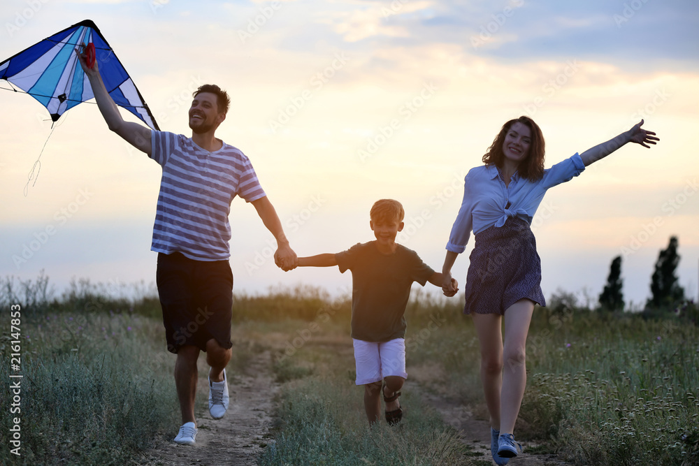 Happy family flying kite outdoors