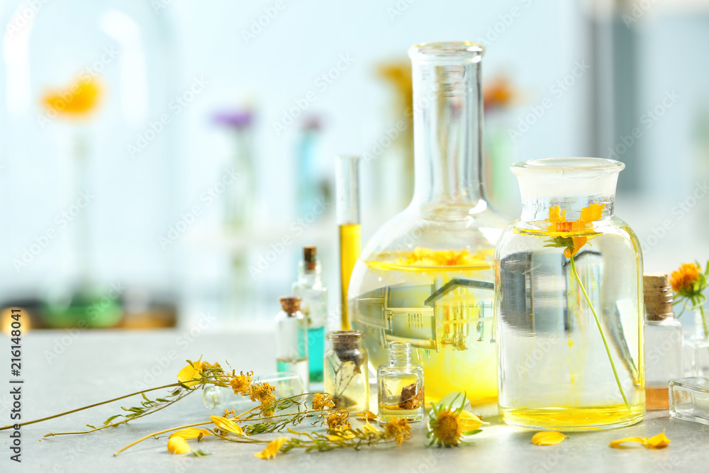 Laboratory glassware with flowers and water on table in laboratory