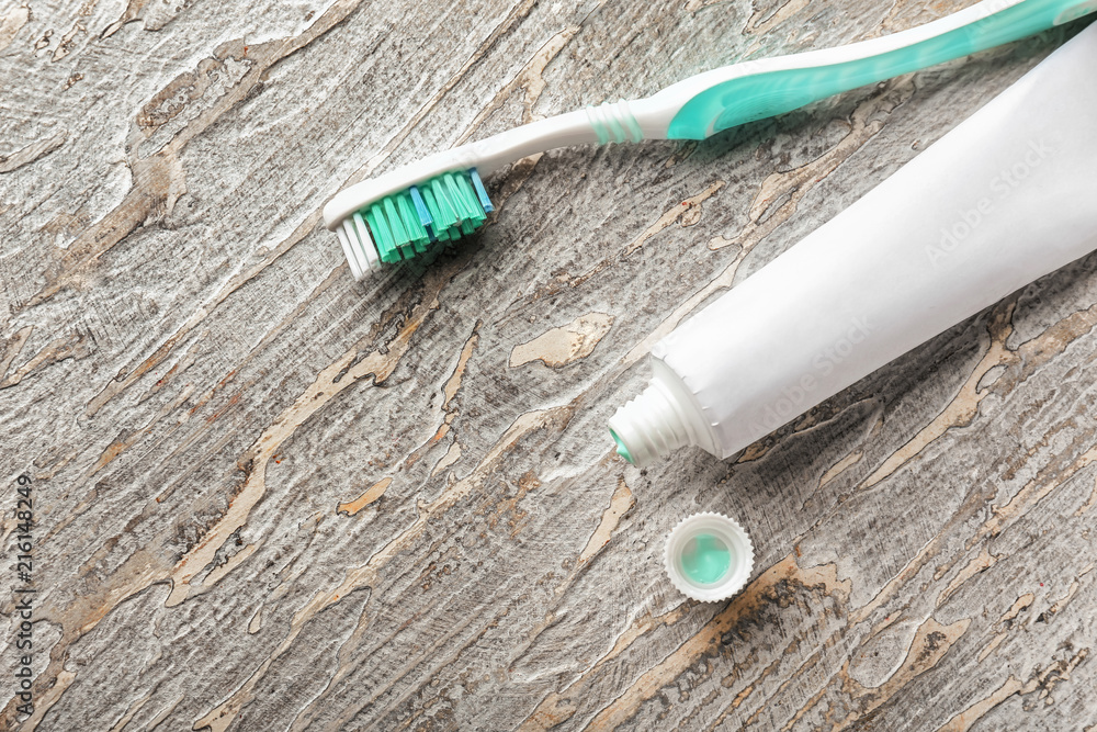 Toothbrush with paste on wooden background