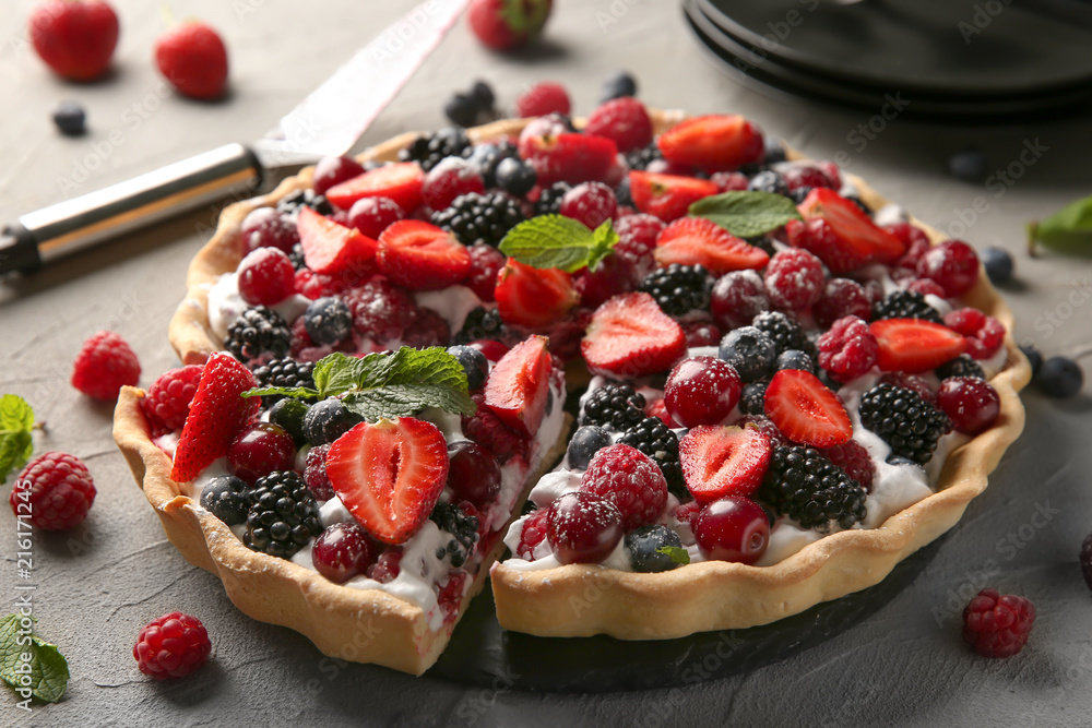 Delicious pie with ripe berries on table