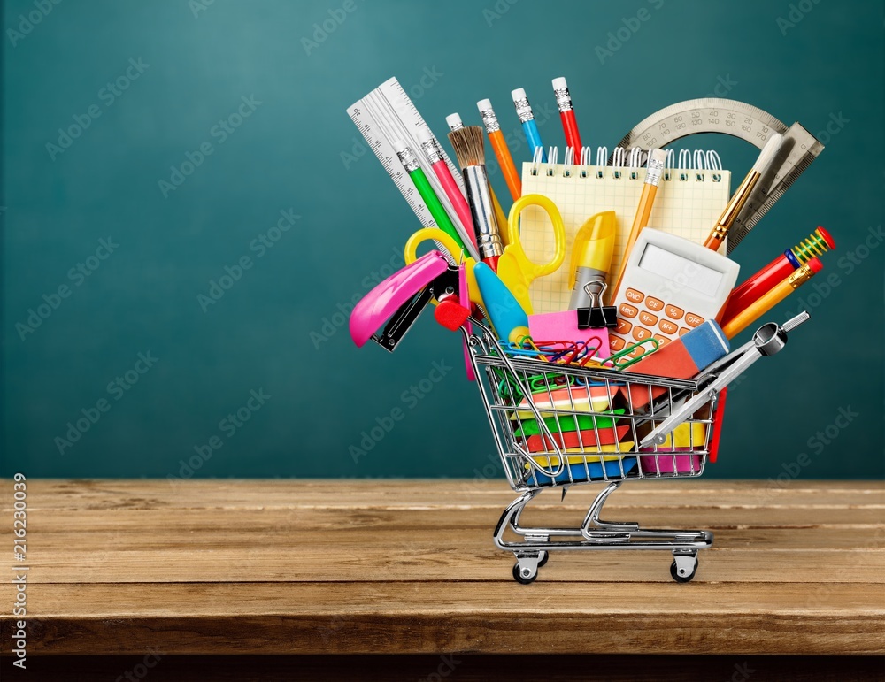 Colorful school supplies in shopping cart