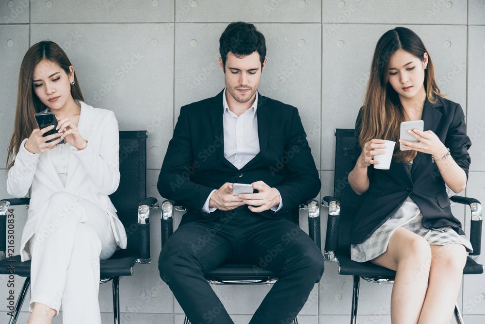 three business woman and man waiting with smartphone at airport