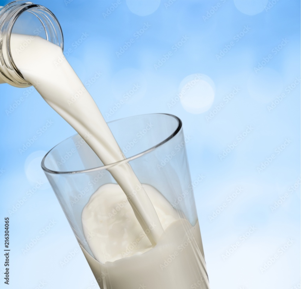 Glass jug of fresh milk on background