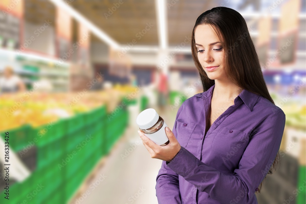 Woman with cart shopping in supermarket