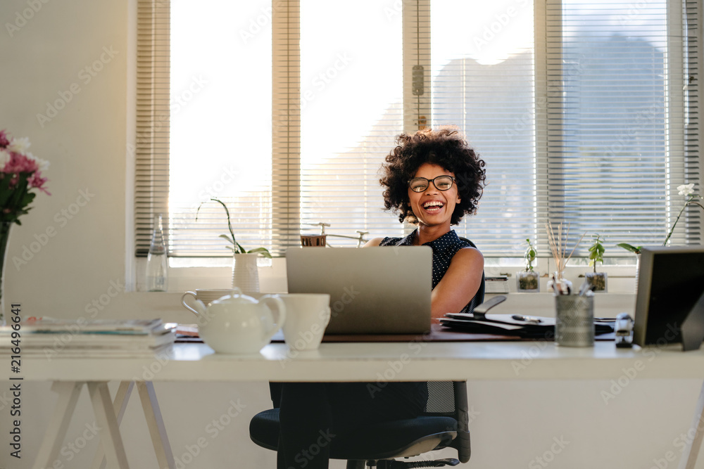 Businesswoman laughing at her desk