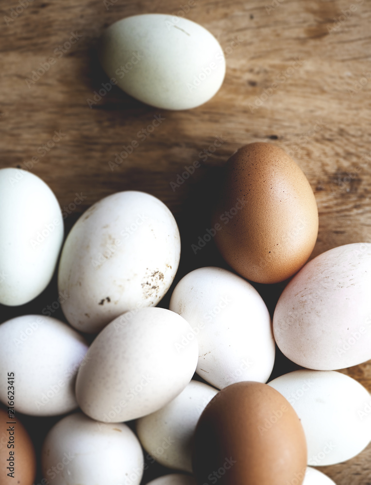 Chicken and duck eggs on wooden floor