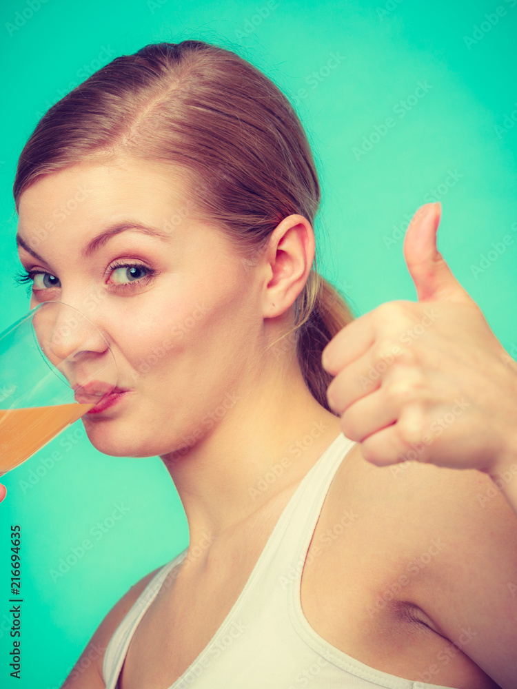 Woman drinking orange flavored drink or juice