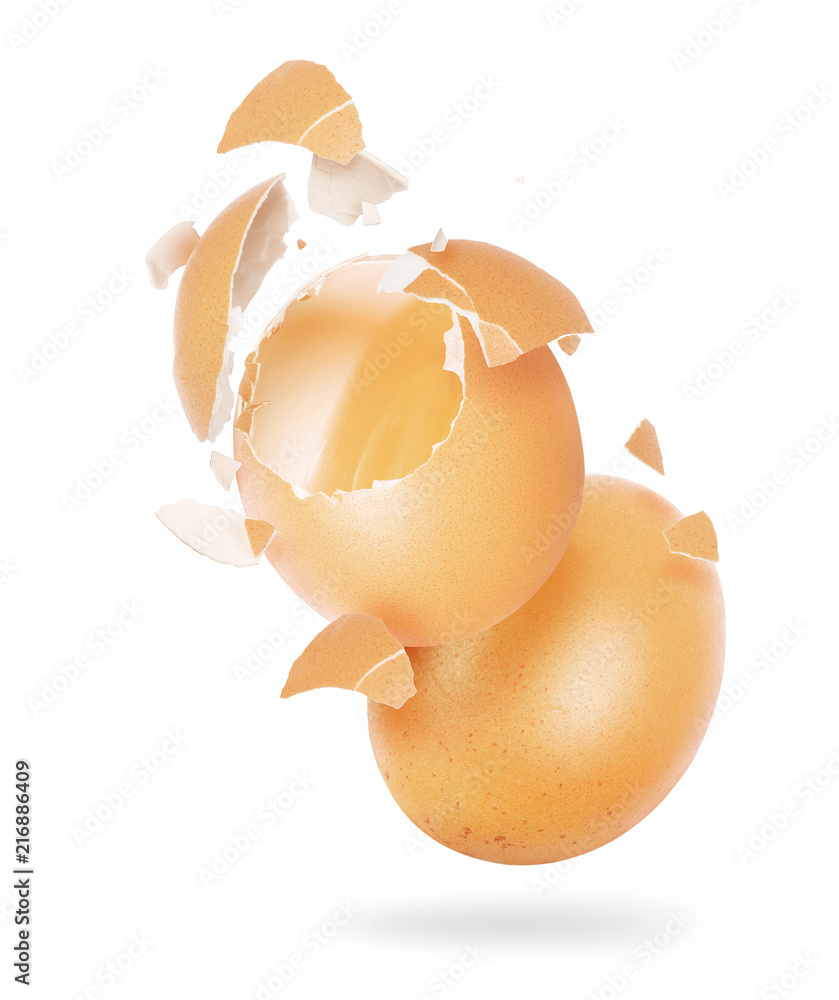 Broken chicken egg in the air on a white background