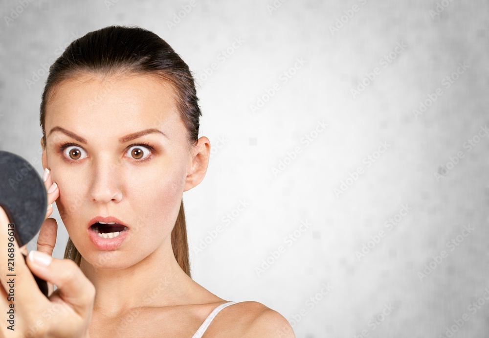 Shocked woman looking in mirror on blurred