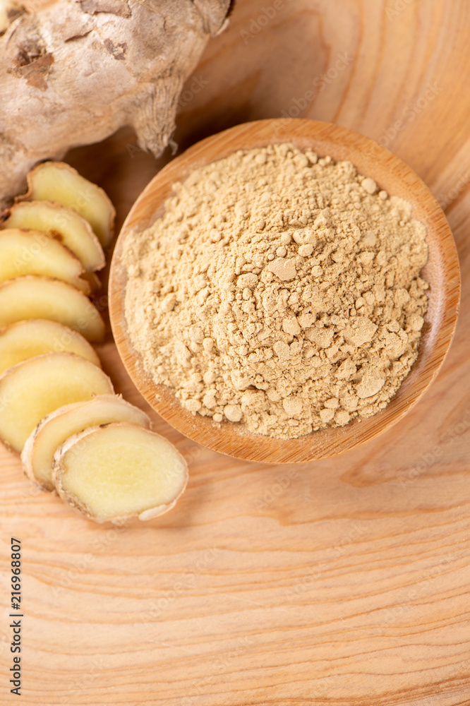 Ginger root, ginger slice and ginger powder on wooden background table, space for text.