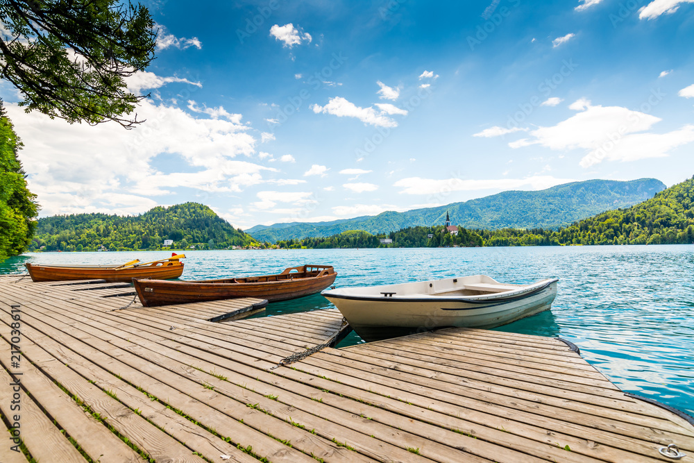 Harbor and boat on the Bled lake, Slovenia. Wooden boats on the pure blue water. Summer day near the