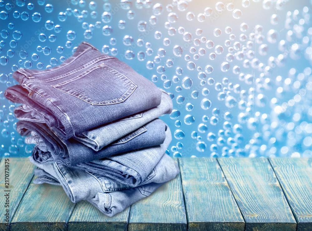 Pile of blue jeans on desk