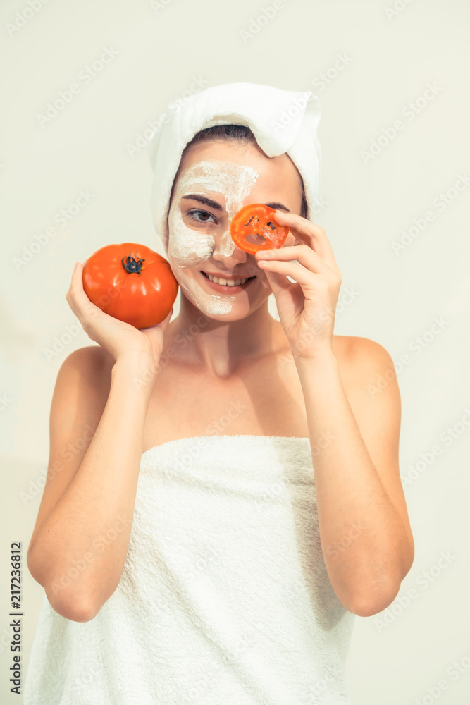 Woman get facial mask with tomato cream extract.