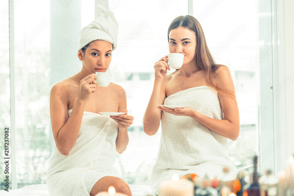 Two women drinking tea in luxury day spa.