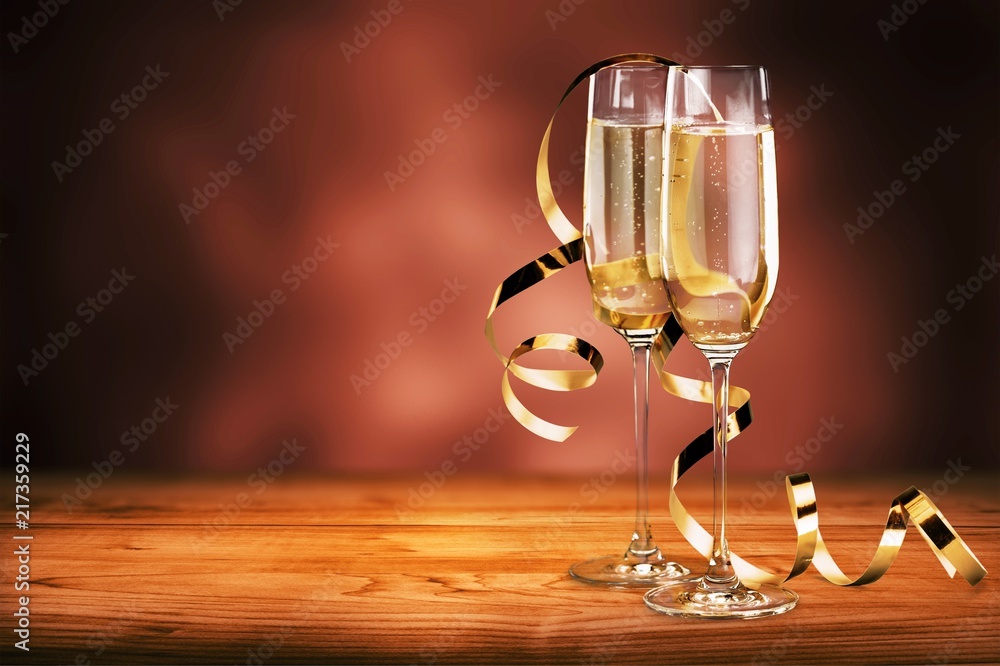 Glasses of champagne with curly ribbon on