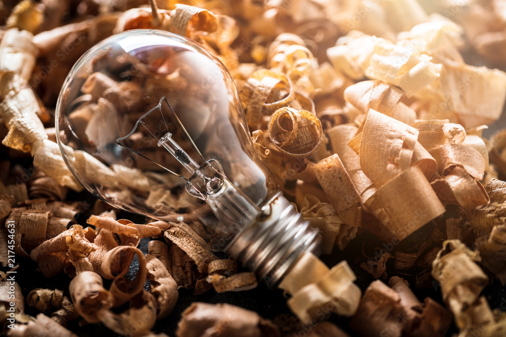 creativity ideas concept with light bulb and wood sawdust on black stone table  vintage color tone