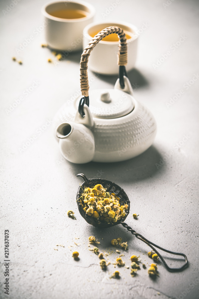 chamomile tea in strainer on vintage background