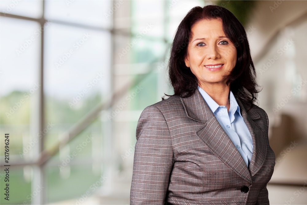 Mature businesswoman wearing formal suit on background