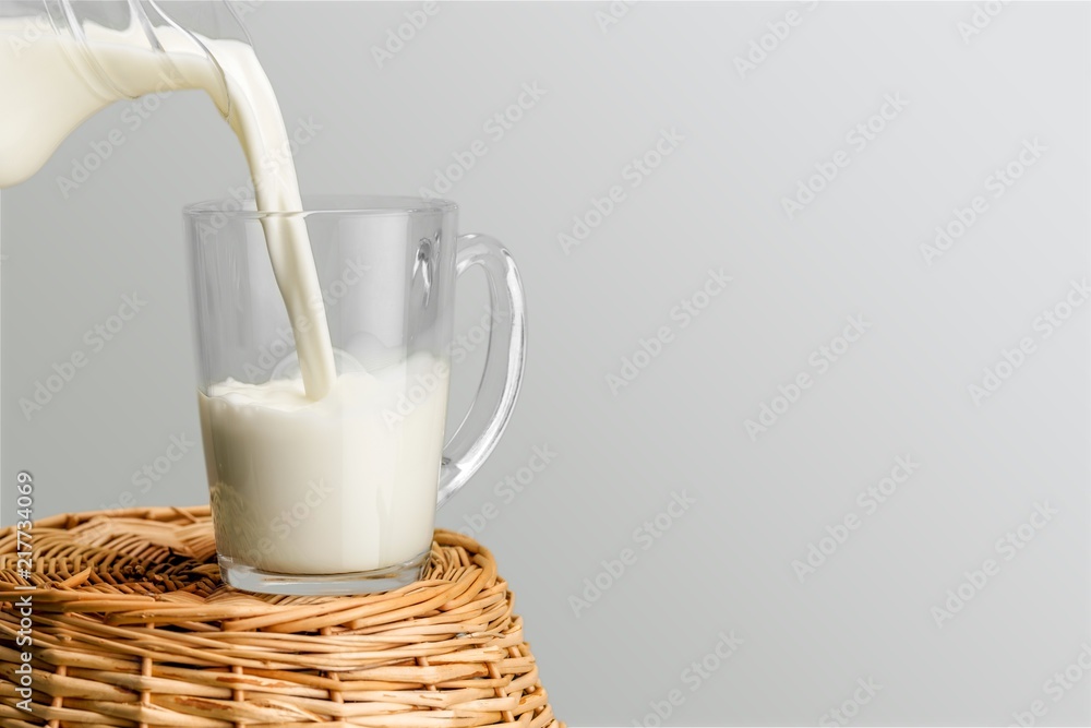 Glass jug of fresh milk  on background