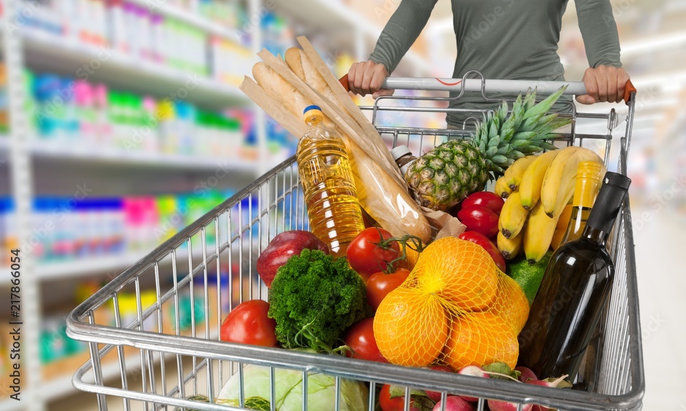 Young happy woman pushing shopping cart